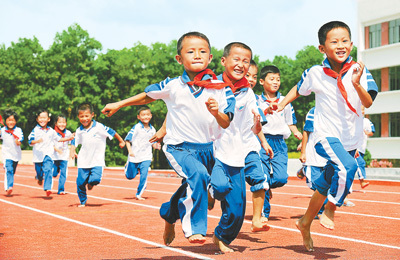 屯昌思源实验学校的学生们在塑胶跑道上奔跑。王军摄