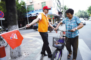 里水镇党员志愿者在街头劝导市民通过马路遵守交通规则。/佛山日报记者周敏摄（资料照片）