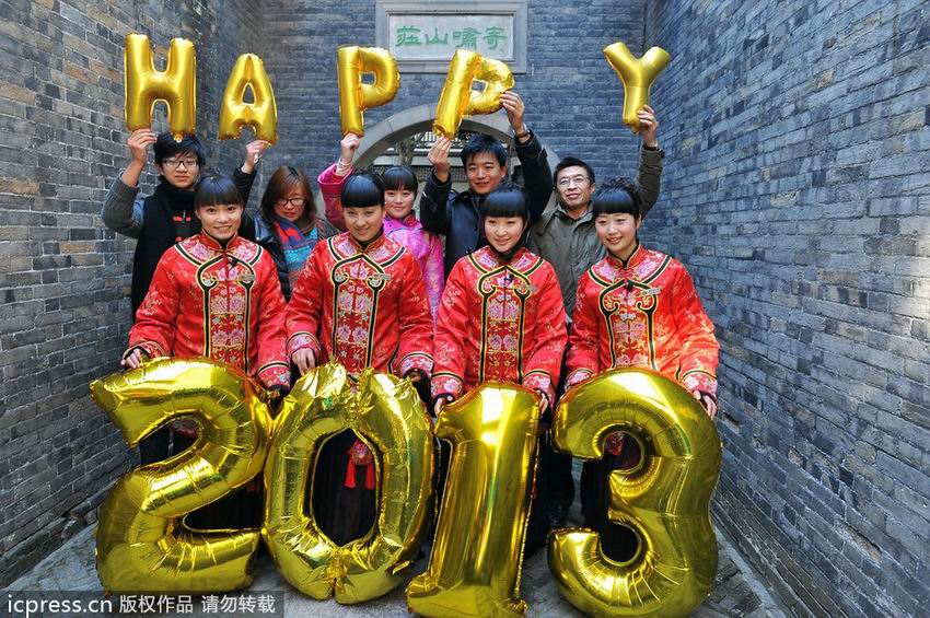 2012年12月31日,江苏扬州市何园景区的“何家千金”导游和游客互动,用气球字体摆出“happy2013”的字样喜迎新年的到来,并在景区内给游客免费发放福字。刘江瑞/东方IC