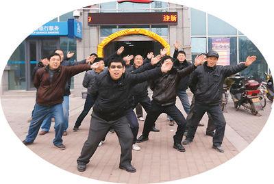 一月二十一日，在武汉东西湖区七雄路星光大道音乐会所门前，一群农民工摆“航母Style”造型、跳骑马舞讨薪。 　　杨涛摄