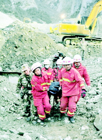 消防官兵在搬运遇难工人遗体。