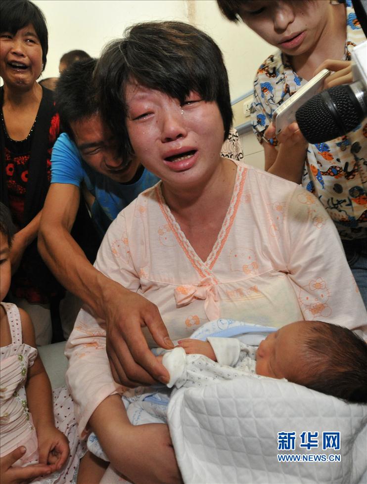 8月5日，在陕西省富平县妇幼保健院病房内,被拐婴儿的母亲怀抱失而复得的孩子泪流满面。