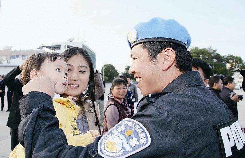 维和民警石磊喜悦地抚摸着女儿的脸