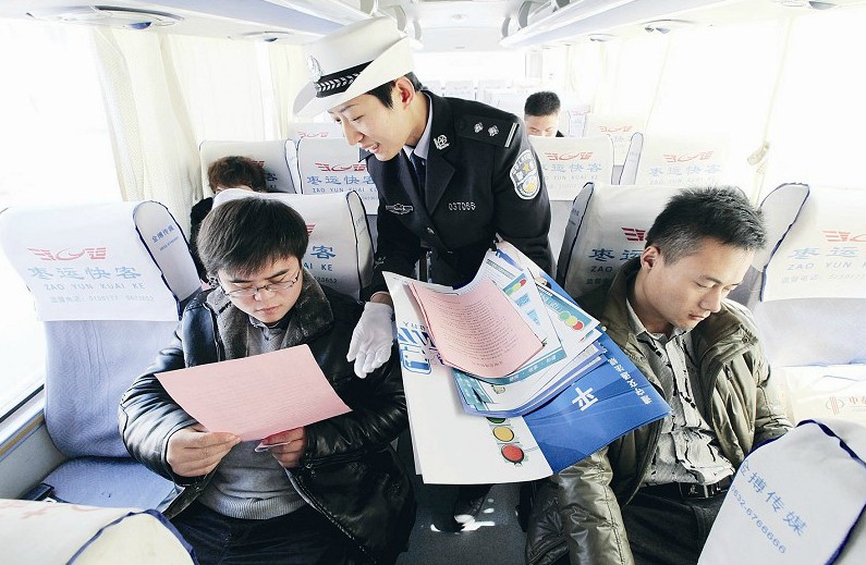 民警向乘客发放“全国交通安全日”宣传材料