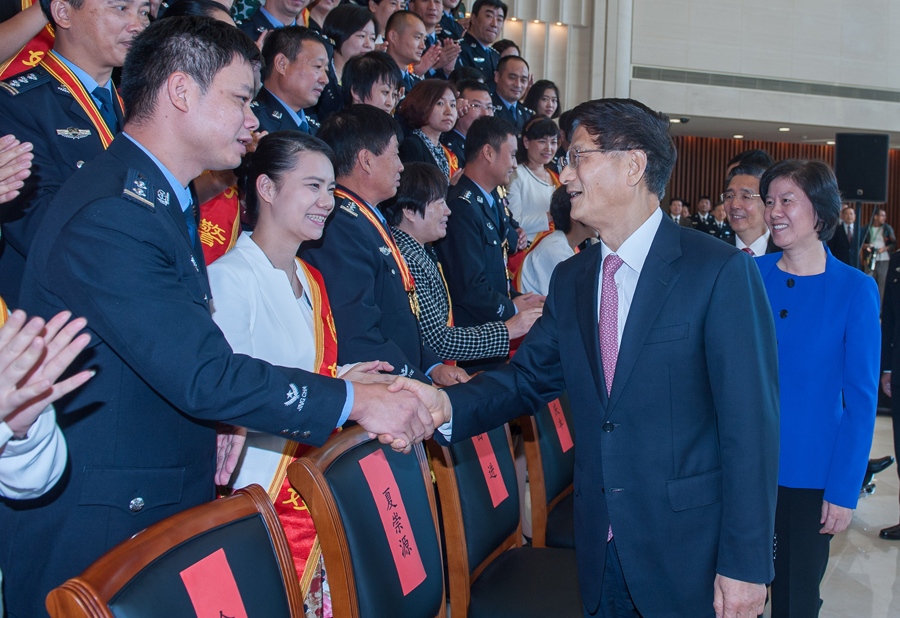 10月8日，中共中央政治局委员、中央政法委书记孟建柱在北京会见好警嫂夫妇。图为孟建柱与好警嫂夫妇亲切握手。 王建军摄