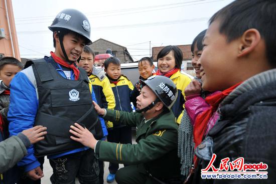 图为一学生穿戴上防刺背心和头盔后开心不已