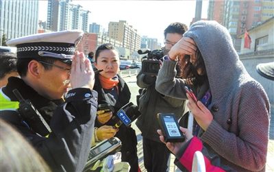 4月11日，一名闯红灯的女子接受交警教育。(资料图片)京华时报记者蒲东峰摄