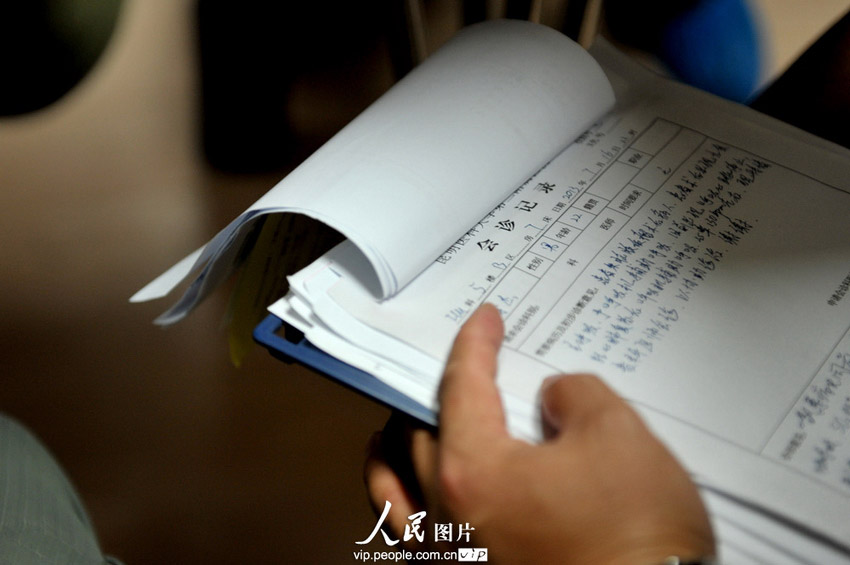 7月17日，中国红十字会工作人员在查看李杰的会诊记录。(郝亚鑫/人民图片)