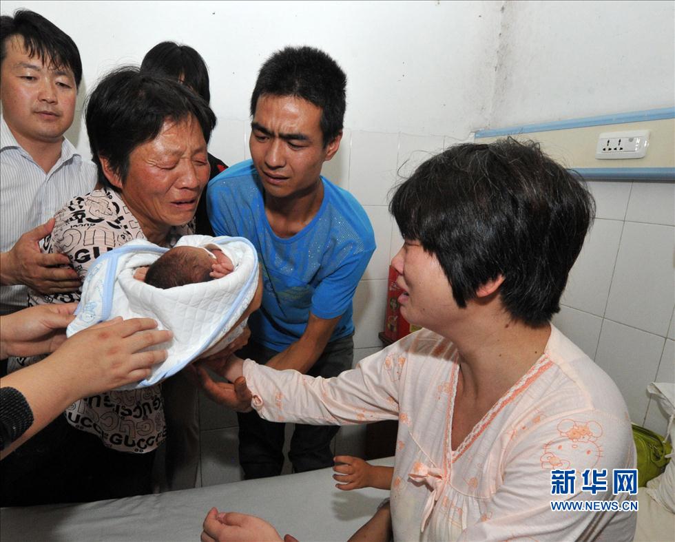 8月5日，在陕西省富平县妇幼保健院病房内，被拐婴儿的母亲接过失而复得的孩子。